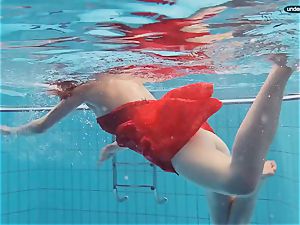 red clad teen swimming with her eyes opened